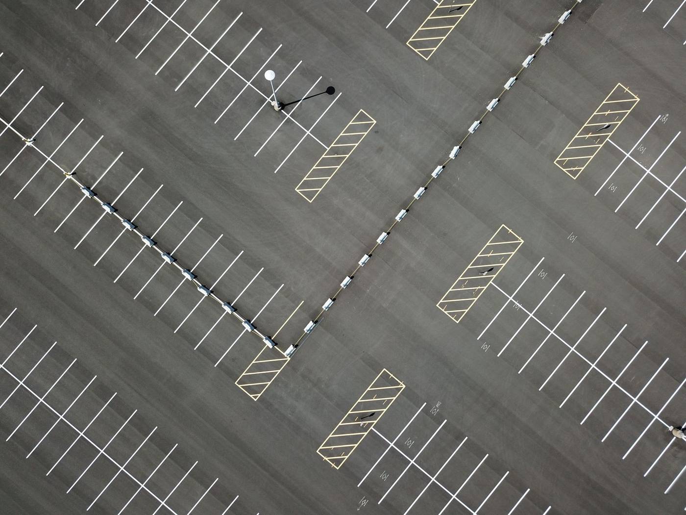 Aerial view of a parking lot with fresh white stall lines and yellow hatched no-parking zones