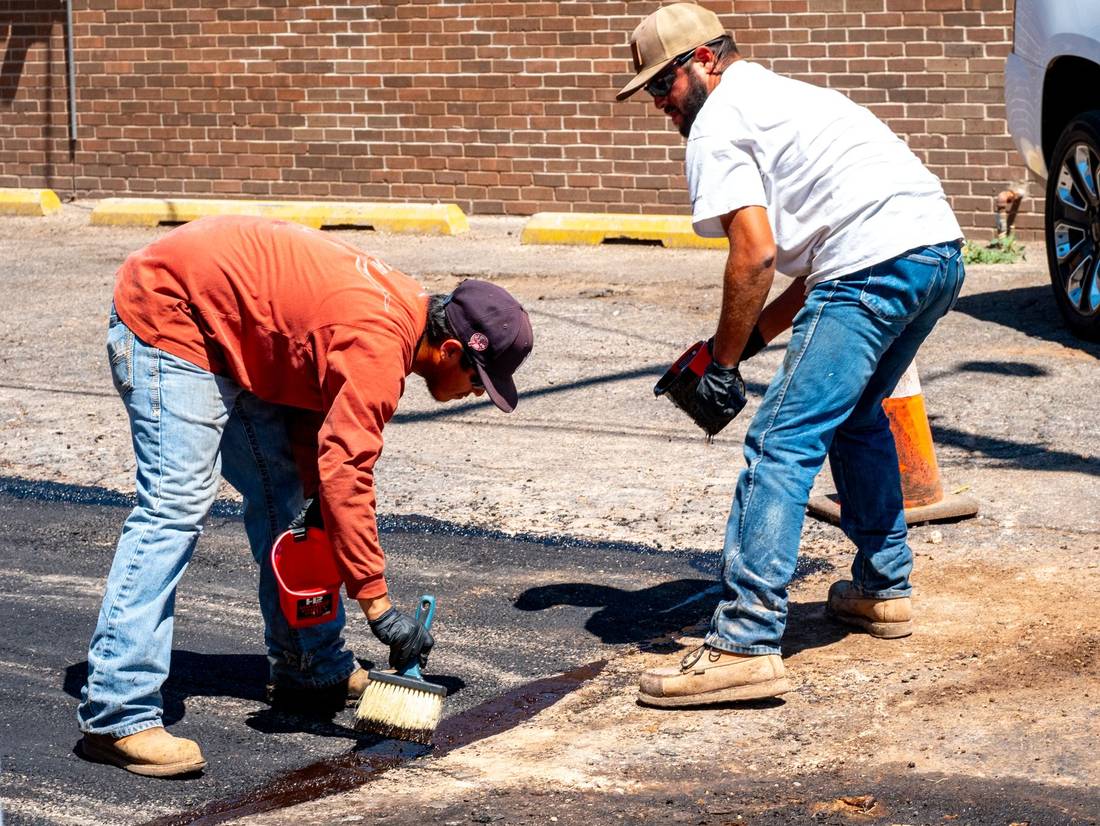Workers patching a section of asphalt